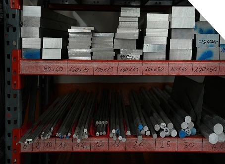 Scaffale con barre tonde e lastre metalliche di varie dimensioni, ordinate per formato in magazzino.