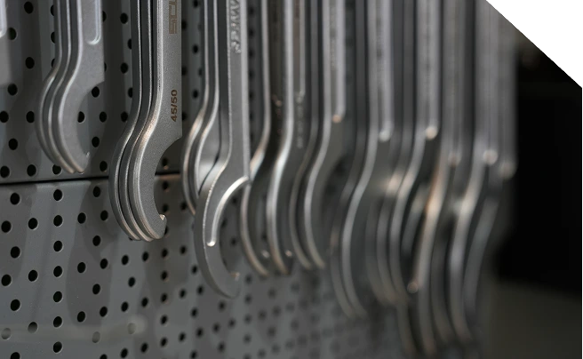 Chiavi combinate professionali esposte su pannello portautensili per officine meccaniche.